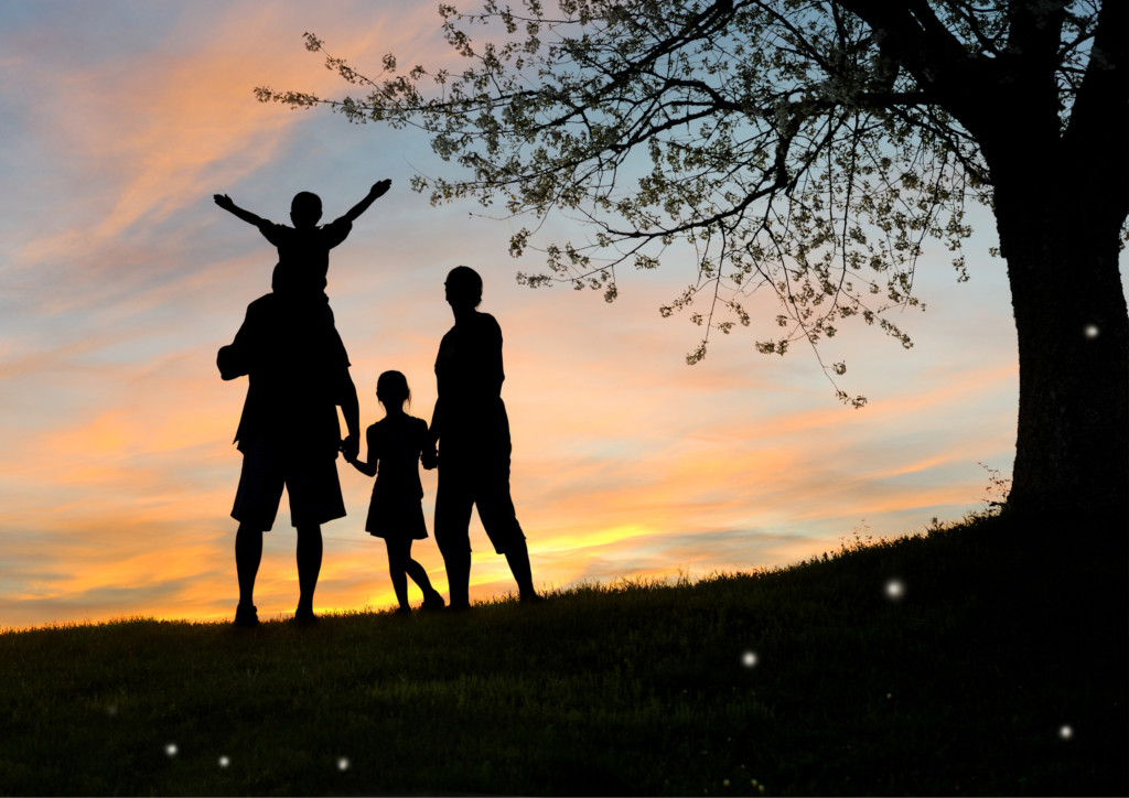 Mother, daughter and father holding hands in a row, with the son on the fathers shoulders at sunset